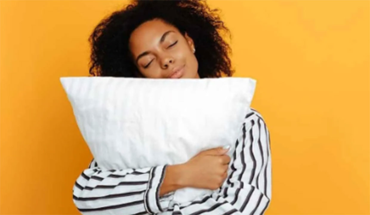 woman in pajamas hugging pillow